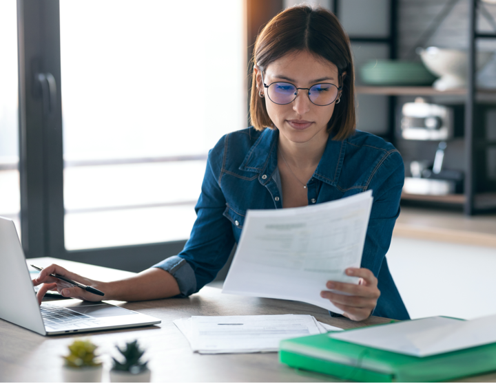 A women sitting by her desk reading