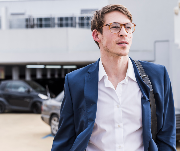 Man with blue jacket, cars in the background