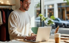 Man behind laptop next to a street