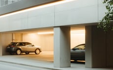 Hell beleuchtetes Parkhaus mit mehreren geparkten Autos.