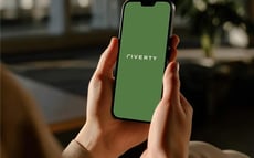 Riverty-Logo auf dem Handy-Display, gehalten in beiden Händen