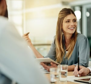 In einem Meeting unterhält sich eine Frau mit einem Mann.