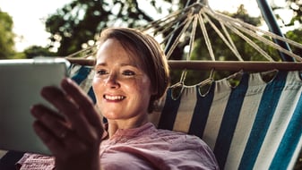 Woman with tablet in a hammock