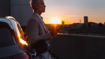 A man charges his EV automobile