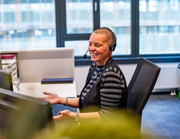 Mitarbeiterin im Callcenter, die gerade mit einer Kundin telefoniert.