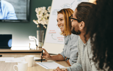 Happy colleagues in a group meeting talking about the Panel Manager