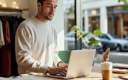 Man behind laptop next to a street