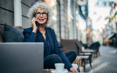 Mevrouw zit achter haar laptop en is aan het bellen