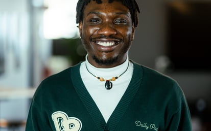 A picture of Timothy. He has short hair and is wearing a dark green outerwear.