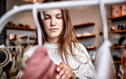 Eine brünette Frau shoppt in einem Modegeschäft