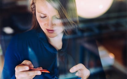 Jonge vrouw kijkt naar haar betaalpas terwijl ze online aan het shoppen is 