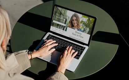 Geöffnetes Macbook, flow.riverty.com ist im Browser geöffnet, während eine Frau sich dort einloggt.