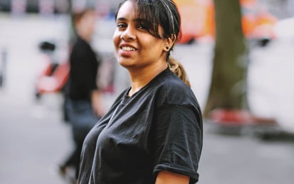 Meera standing in front of a tree