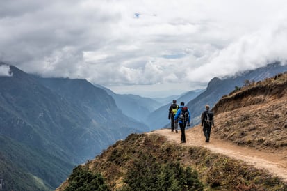 Drei Wanderer auf ihrem Weg durch ein Gebirge