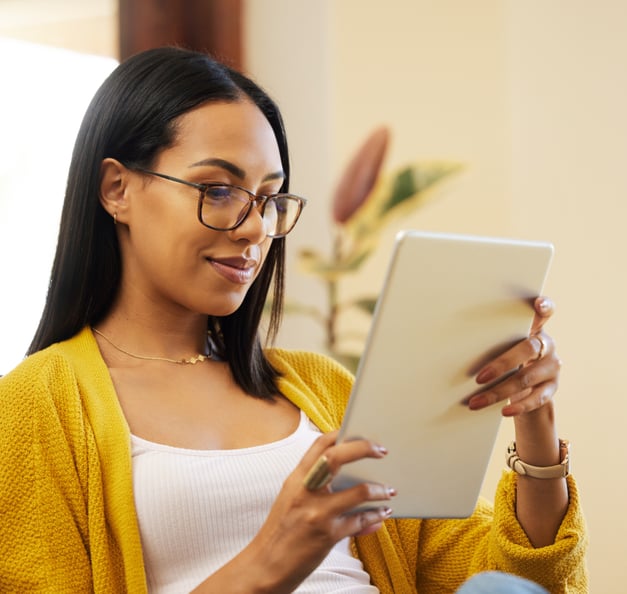 a smiling women looking at her ipad