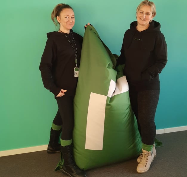 Antonina and her colleague standing next to a Riverty beanbag