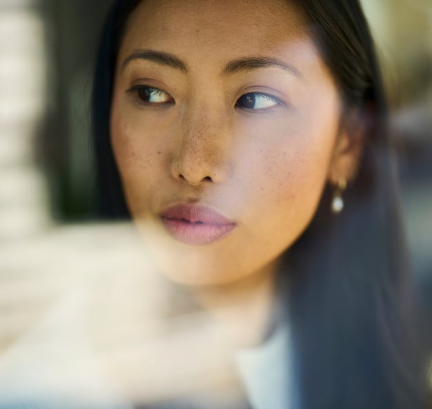 Frau die durch ein Fenster blickt