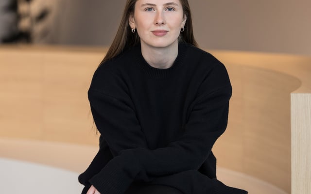 Polina Dmitrenko, External Communications Managerin DACH bei Riverty, sitzend in einem modernen Bürointerieur.