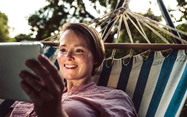 Woman with tablet in a hammock