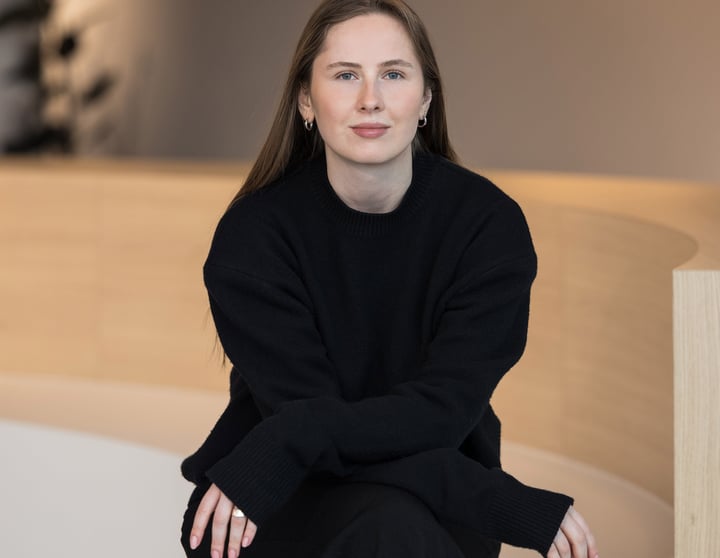 Polina Dmitrenko, External Communications Managerin DACH bei Riverty, sitzend in einem modernen Bürointerieur.