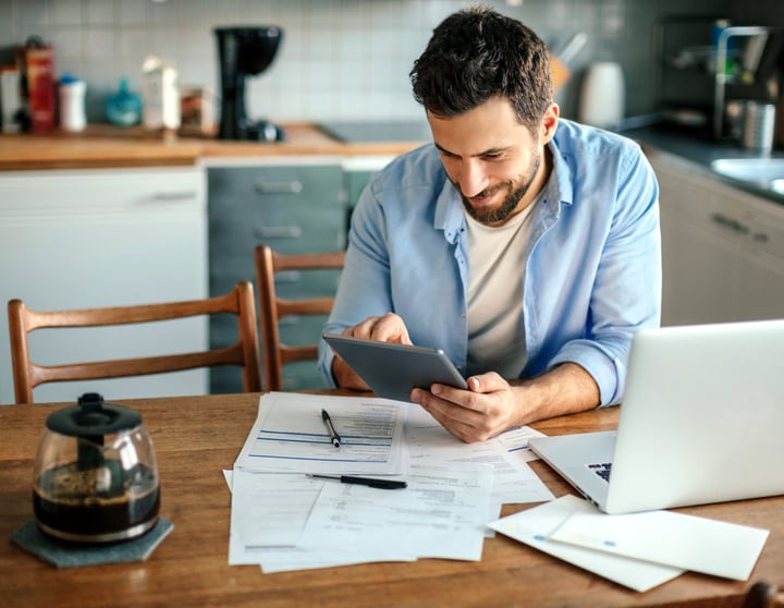 A man with a blue shirt is checking his finances