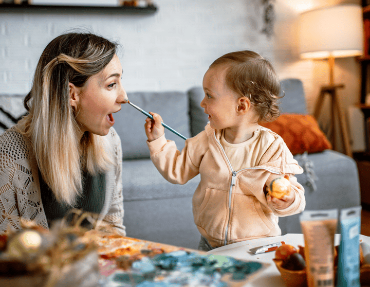 Eine Mutter und ihre junge Tochter bemalen gemeinsam Ostereier