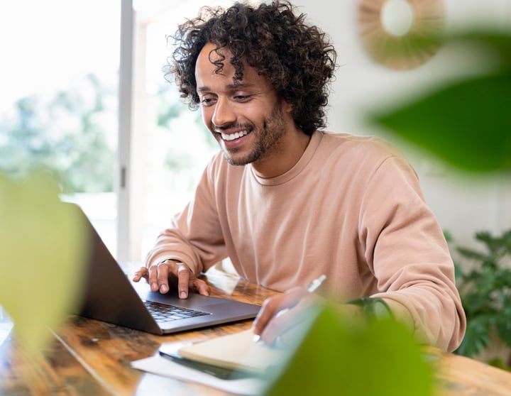 Junger Mann sichtlich entspannt am Laptop - ohne Stress 