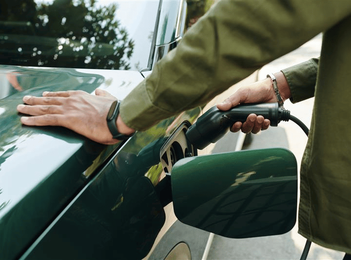Person, die ihr Fahrzeug auflädt