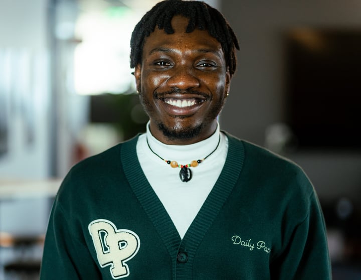 A picture of Timothy. He has short hair and is wearing a dark green outerwear.