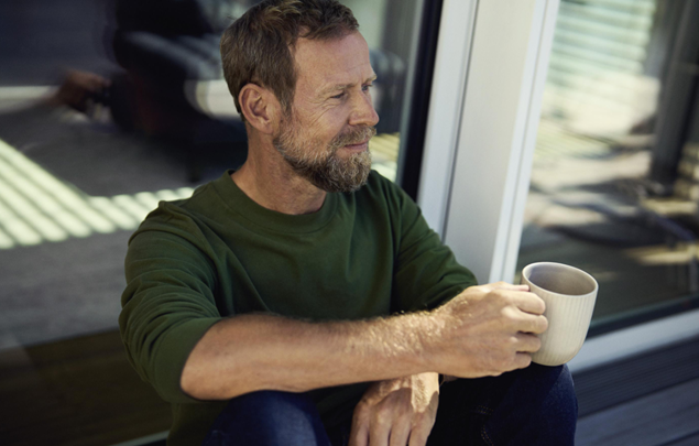 Man på en plats med kaffe i handen