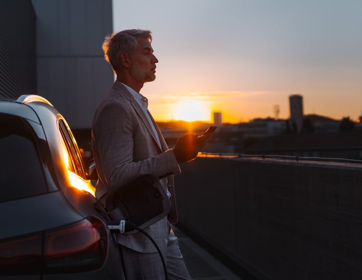 A man charges his EV automobile