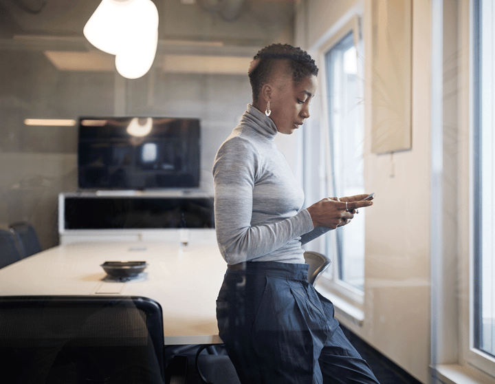 Frau mit Smartphone in einem modernen Büro