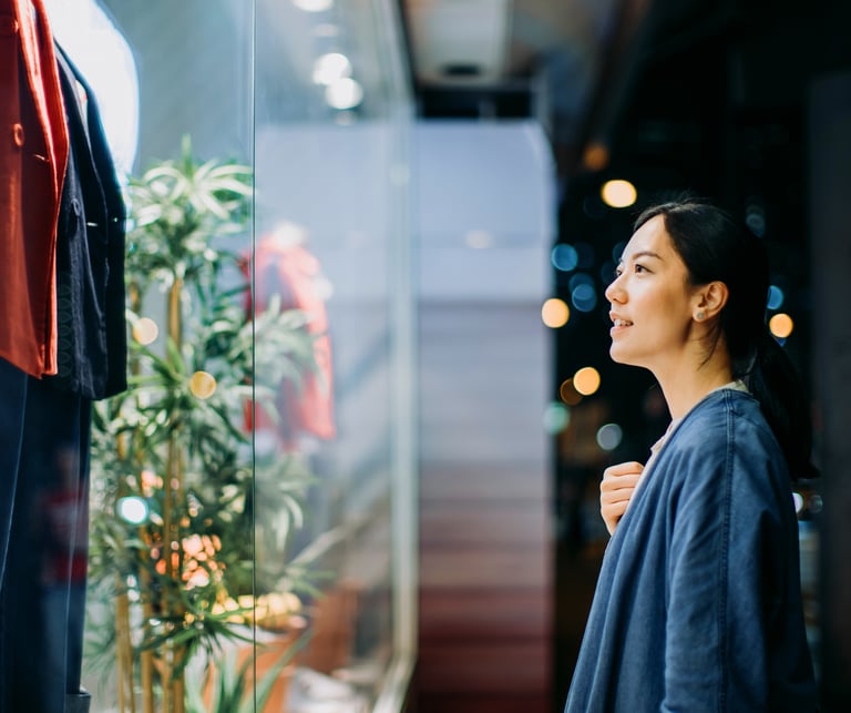 Junge Frau, die ein Schaufenster betrachtet